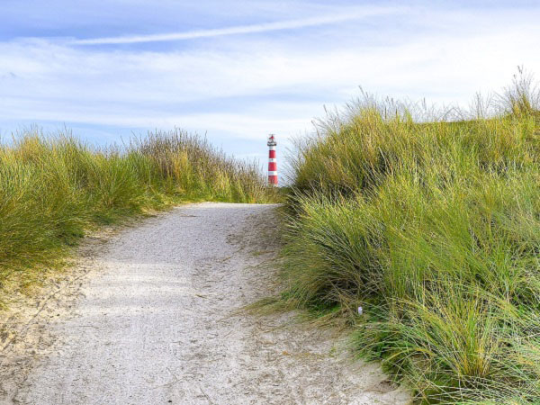 Een foto van de duinen en vuurtoren op het eiland Ameland
