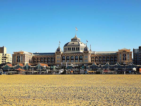 Een foto van het strand van Scheveningen met in de verte het luxueuze Grand Hotel Amrath Kurhaus