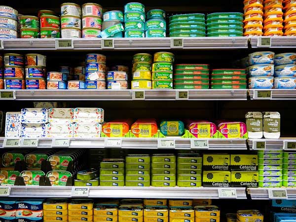 Een foto van rekken voedsel in blik in een supermarkt